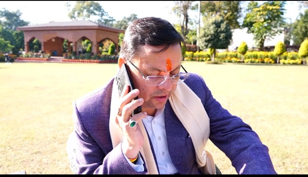 मुख्यमंत्री पुष्कर सिंह धामी फोन पर बातचीत करते।