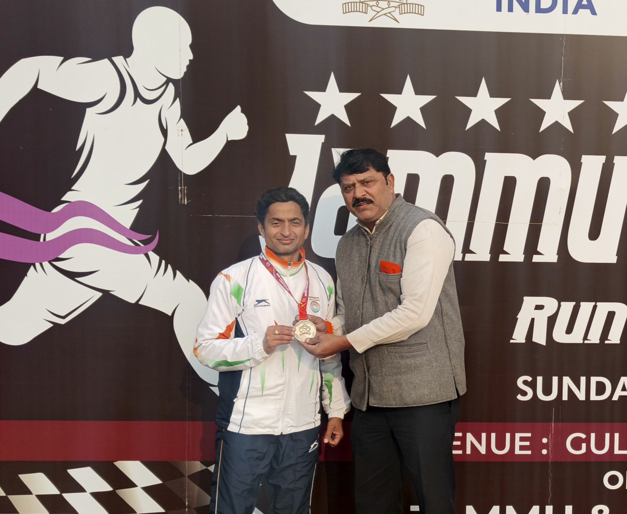 जम्मू:- शिवसेना (यूबीटी) जम्मू-कश्मीर ईकाई प्रमुख मनीश साहनी ने जम्मू-कश्मीर पुलिस द्वारा 'रन फॉर यूनिटी-जम्मू मैराथन 2025' मे 45+ आयु वर्ग के विजेता जोगा सिंह को विशेष सम्मानित किया. साहनी ने राष्ट्रीय एकता और अखंडता के संदेश को लेकर मैराथन के आयोजन पर जम्मू-कश्मीर पुलिस की जमकर सराहना की. विजेता जोगा सिंह ने अपने संदेश में कहा कि उम्र सिर्फ एक नंबर है , कड़ी मेहनत, सही प्रशिक्षण और हार न मानने की मानसिकता से कोई भी मैराथन व प्रतियोगिता जीती जा सकती है. उनहोंने कहा कि अपने स्वास्थ्य और फिटनेस के लिए दौड़ें, चाहे उम्र कुछ भी हो. जोगा सिंह ने बताया कि वह पिछले साल भी जम्मू मैराथन में विजेता रहे थे. जोगा सिंह एक अंतराष्ट्रीय एथलीट है . वह अमेरिका की बोस्टन मैराथन (Boston Marathon) दुनिया की सबसे पुरानी और प्रतिष्ठित वार्षिक मैराथन में भी चार बार क्वालीफाई कर चुके हैं. जोगा सिंह Indian  रेलवे , लुधियाना में सीआईटी के पद पर नियुक्त है. जोगा सिंह ने शिवसेना प्रदेश प्रमुख द्वारा विजेताओं को विशेष सम्मानित व हौसला अफ़ज़ाई पर धन्यवाद दिया