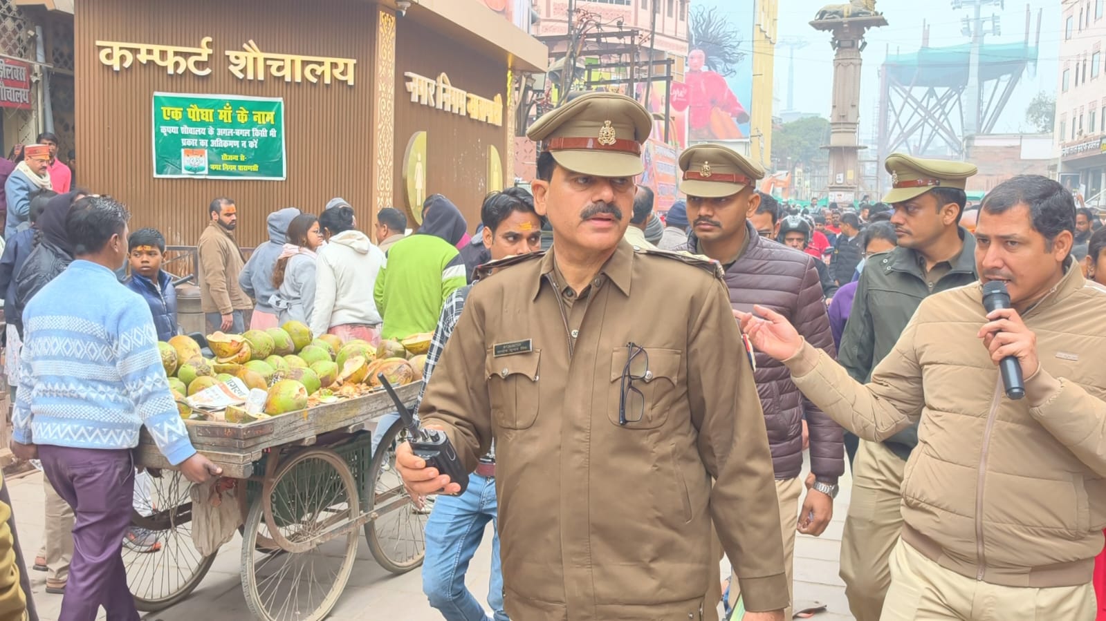 लोगों को भीड़ में सावधानीपूर्वक चलने का अनाउंस करते अफसर