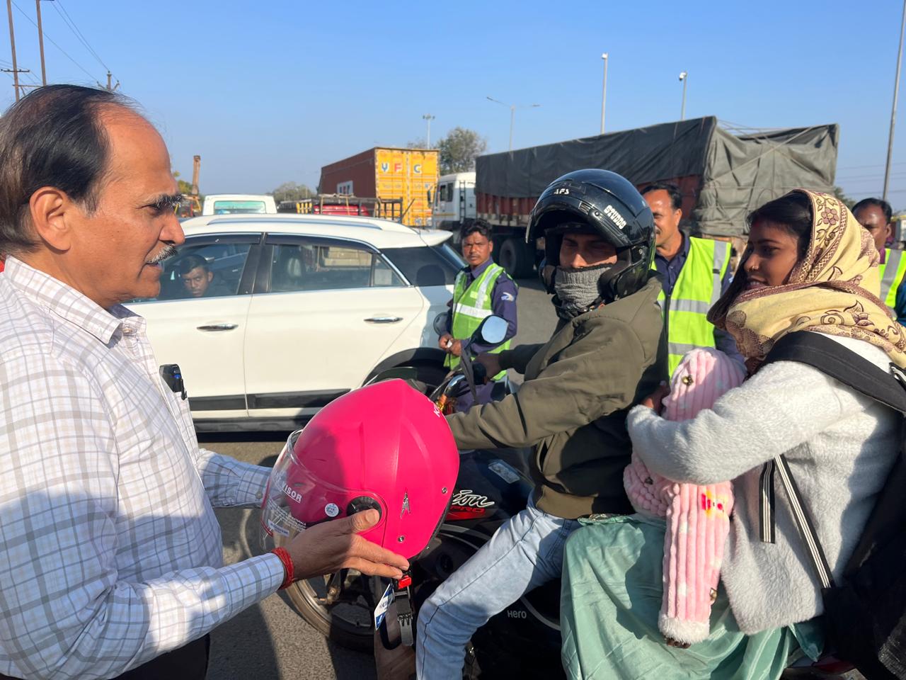 बाइक सवारों के बीच हेलमेट का वितरण