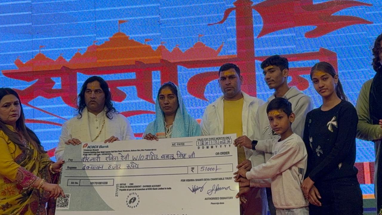 शहीद हेमराज सिंह की वीरनारी धर्मवती एवं उनकी पुत्री को चैक सौंपते हुए देवकीनंदन महाराज