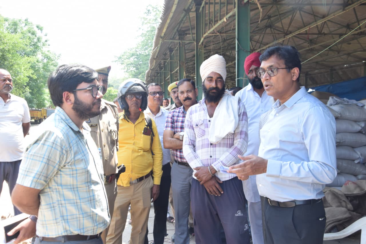 मंडी में किसान से बात करते डीएम अंजनी कुमार सिंह