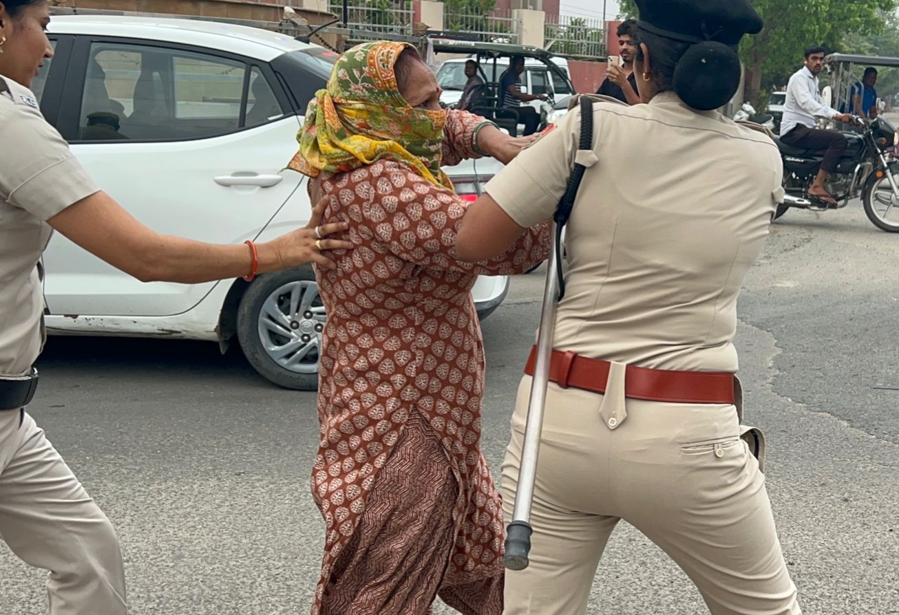 सफाई का विरोध कर रही महिला सफाई कर्मचारी को पकड़ कर ले जाती महिला पुलिस अधिकारी।