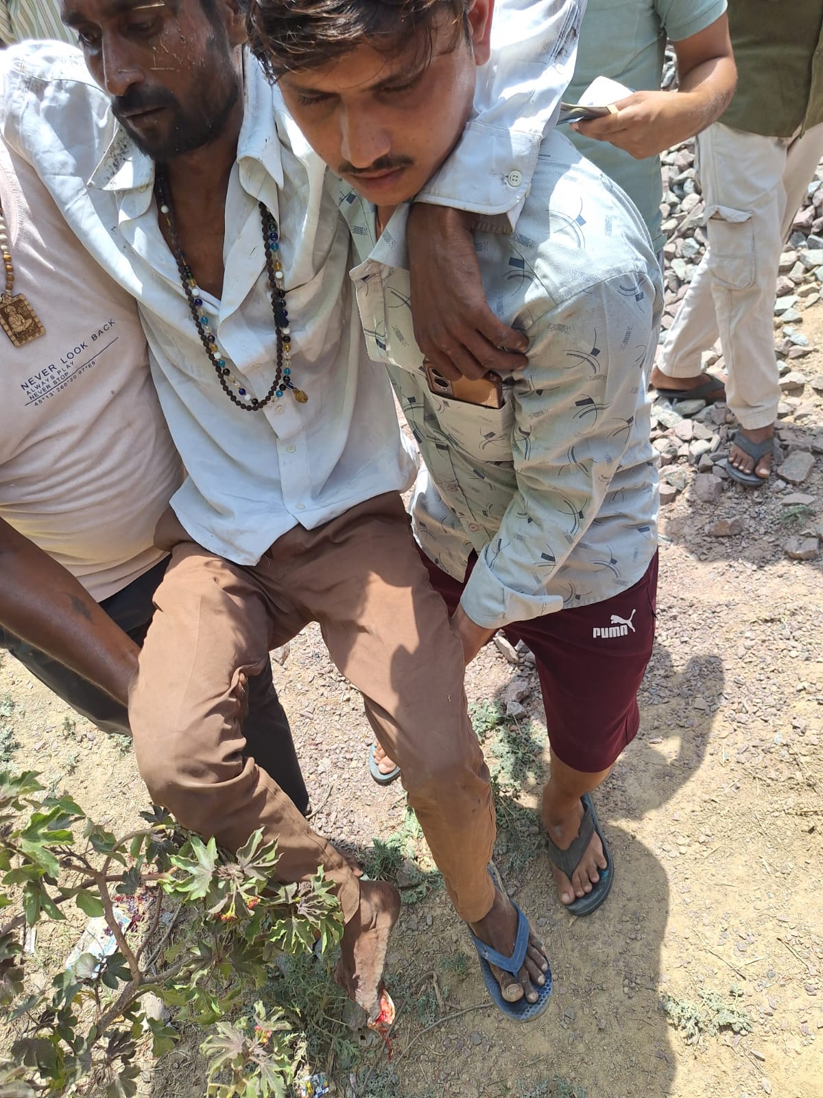 ट्रेन की गिरफ्त में घायल युवक को अस्पताल ले जाते
