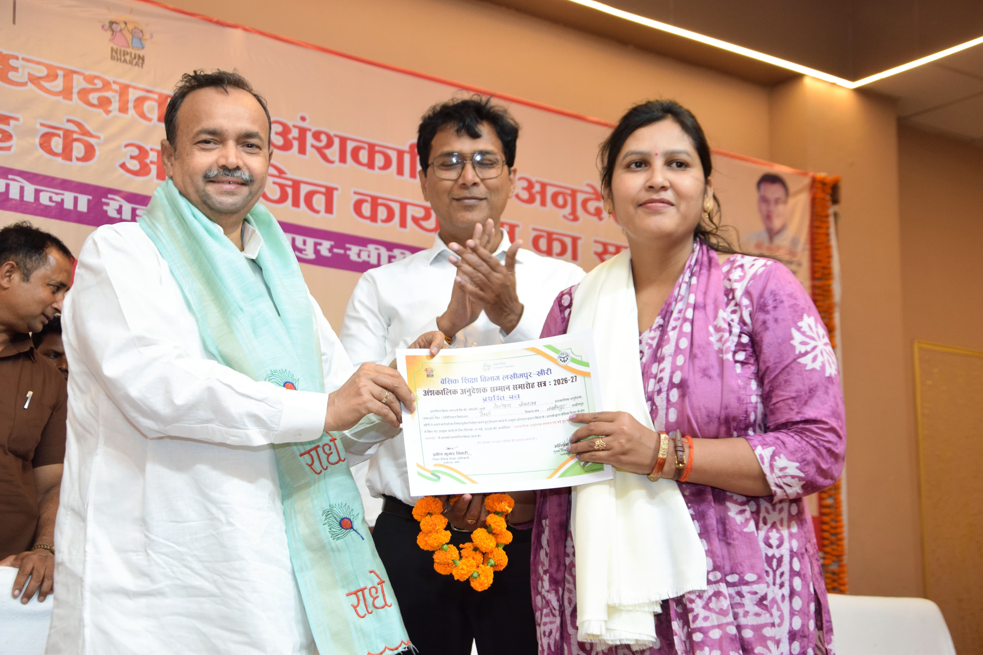 शिक्षामित्र को बढ़ी हुई राशि का चेक प्रदान करते हुए मंत्री जेपीएस राठौर व डीएम अंजनी कुमार सिंह
