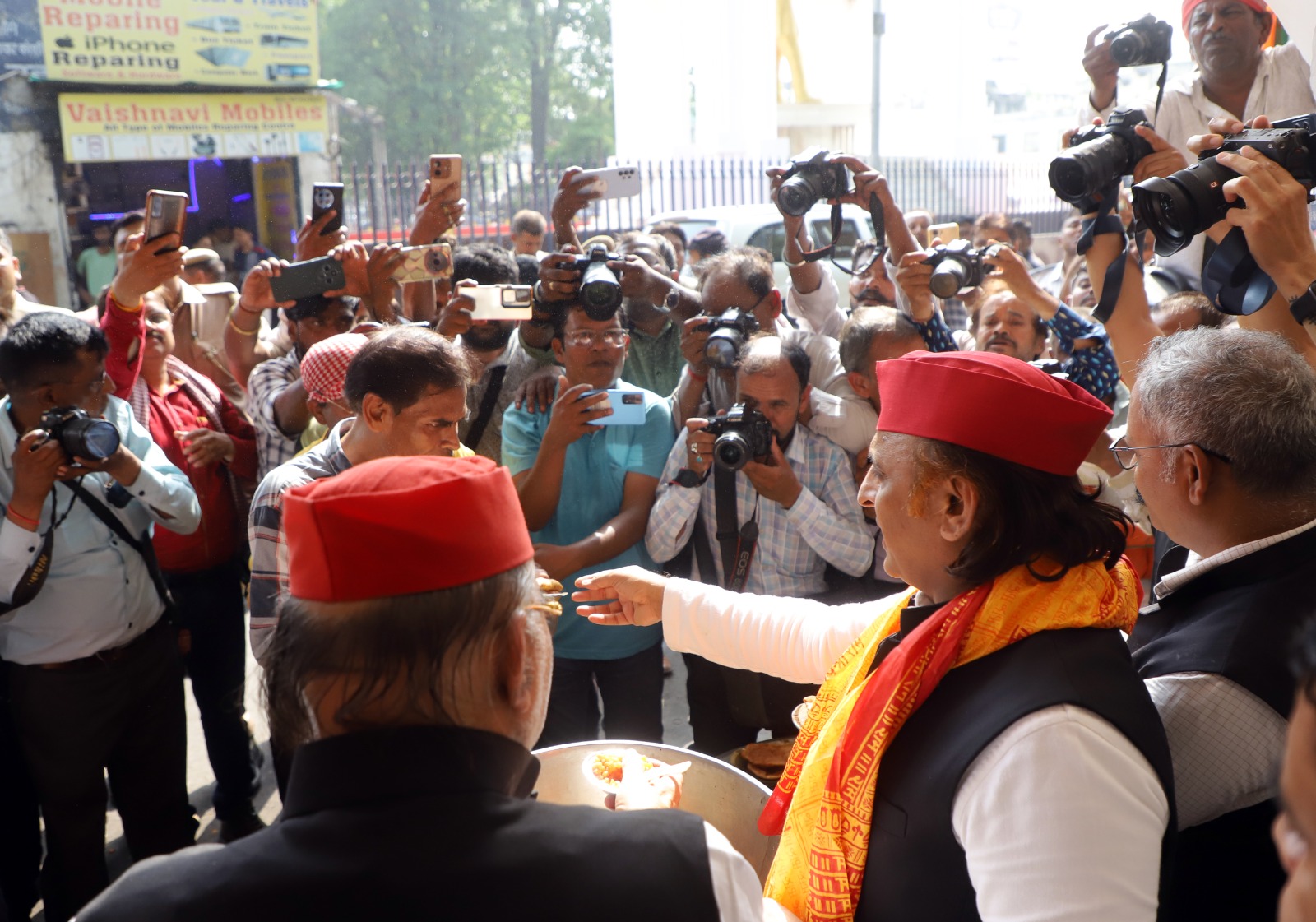 लखनऊ के हजरतगंज में भंडारे में प्रसाद बांटते अखिलेश यादव