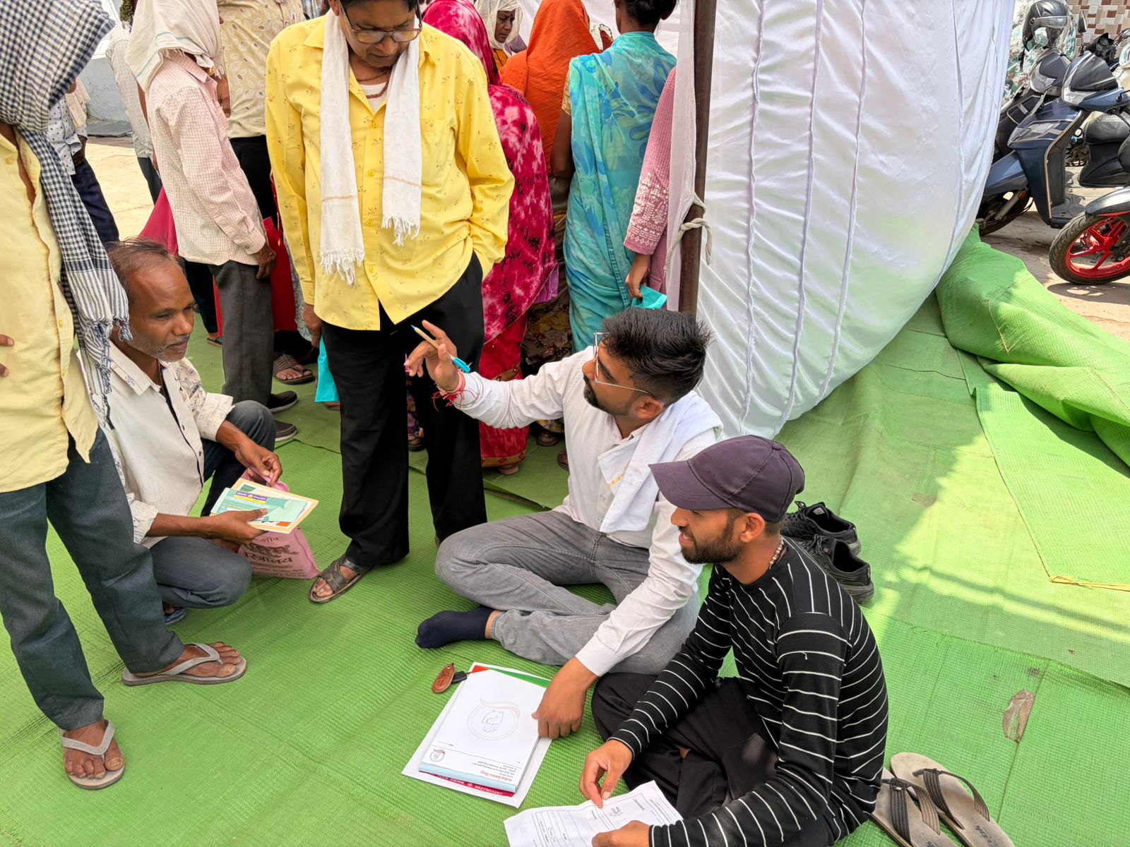 जमीन में बैठकर वार्डवासियों का आवेदन लेते हुए जोधापुर वार्ड पार्षद सत्येंद्र देवांगन।