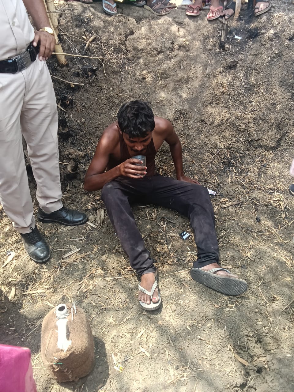 हाईटेंशन टावर से नीचे उतरकर बैठा हुआ युवक।