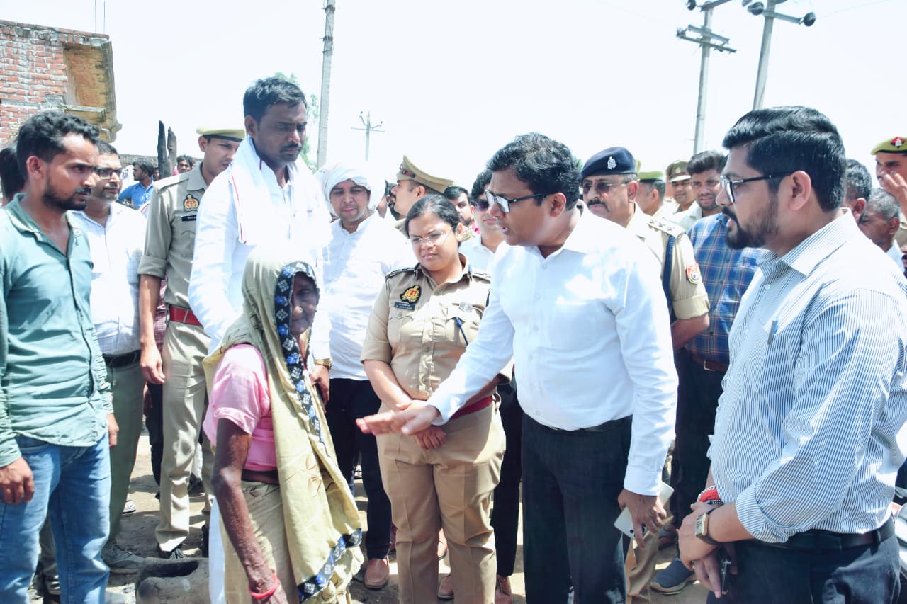 पीड़ित बुजुर्ग महिला से बात करते डीएम अंजनी कुमार सिंह