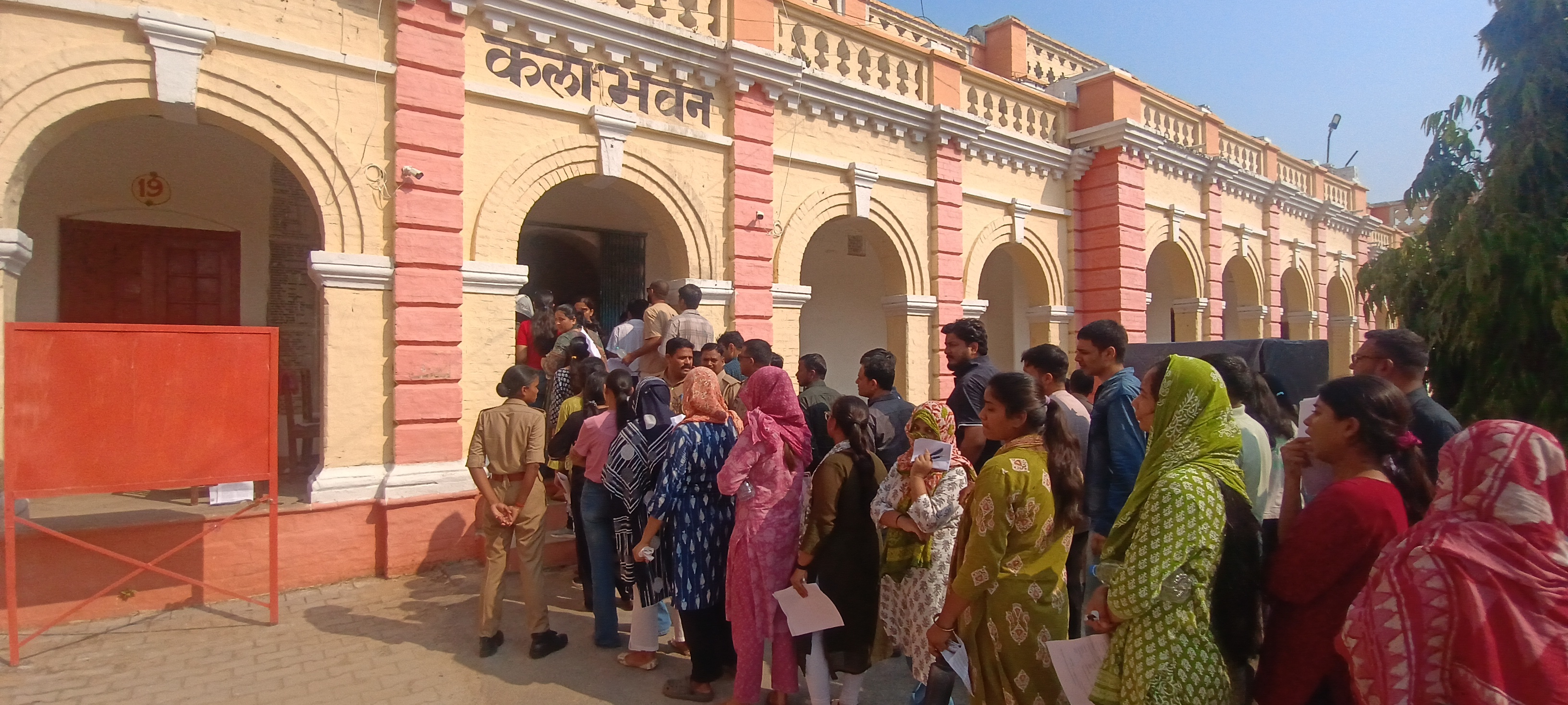 परीक्षा केंद्र पर पहुंचे छात्रों की तलाशी लेते हुए