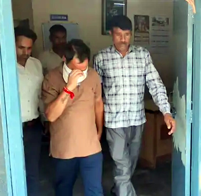 रिश्वत लेते पकड़े गए पुलिसकर्मी को ले जाते एसीबी टीम के सदस्य