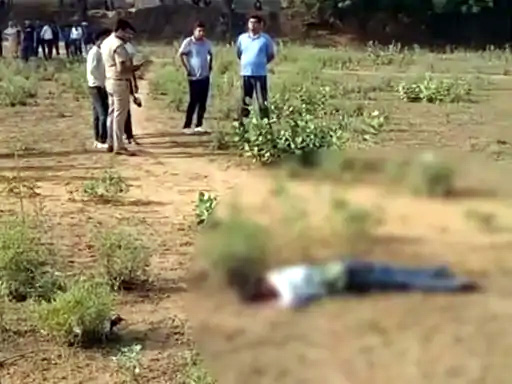 मैदान में पड़ा शव, जांच करती पुलिस