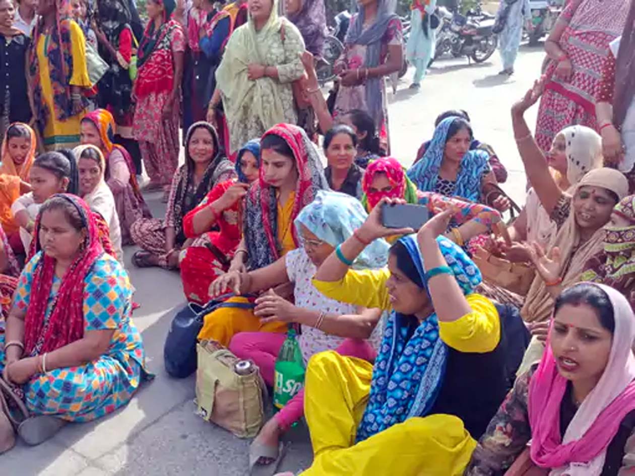 जाम के दौरान सड़क पर बैठी महिलाएं।