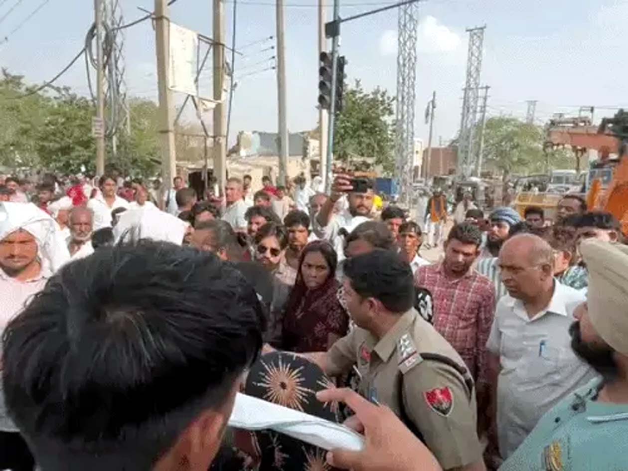 जाम लगाते मृतका के परिजनाें काे समझाते पुलिस कर्मचारी।