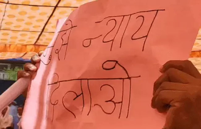 नारनौल में मुख्यमंत्री के सामने पोस्टर लहराता हुए युवक।