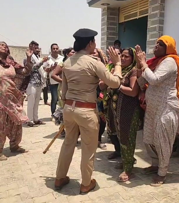 महिलाओं को समझाते हुए पुलिसकर्मी।