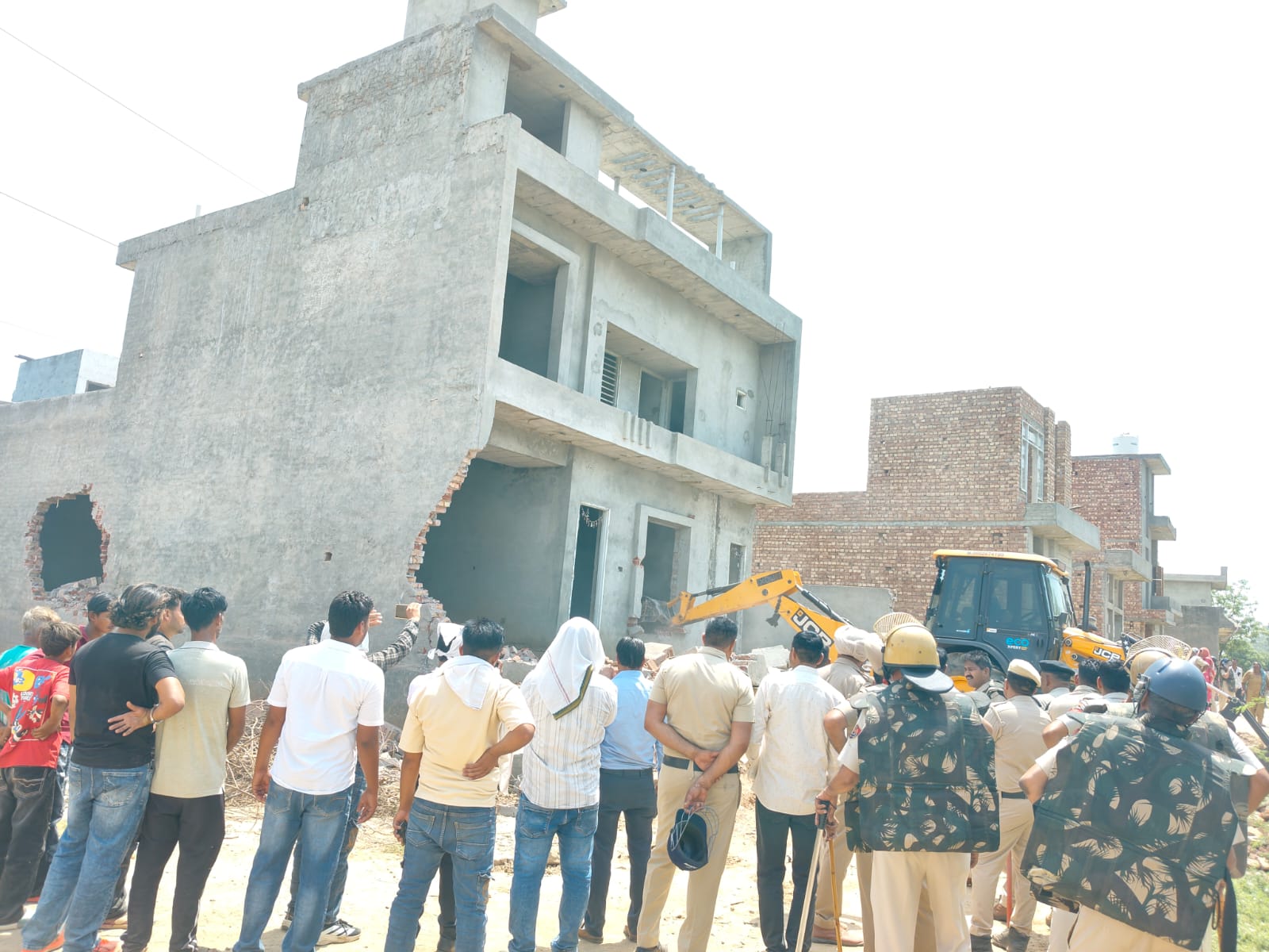 नशा तस्करों के मकानों को जेसीबी मशीन की सहायता से ढहाते हुए।