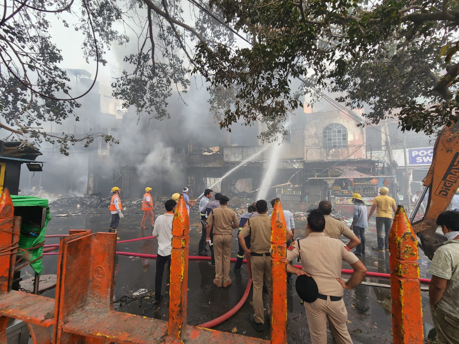 रोहतक के डी  पार्क पर लगी आग को बुझाते दमकल कर्मी