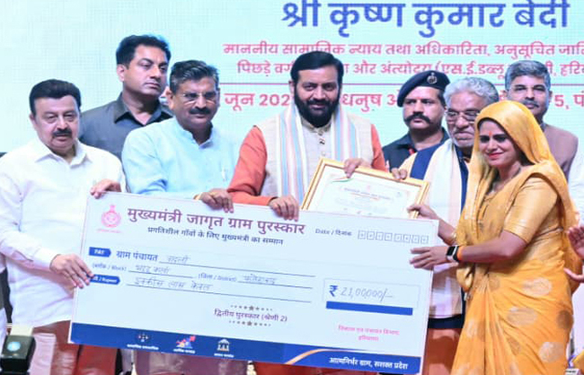हरियाणा के मुख्यमंत्री महिला प्रतिनिधि काे सम्मानित करते हुए