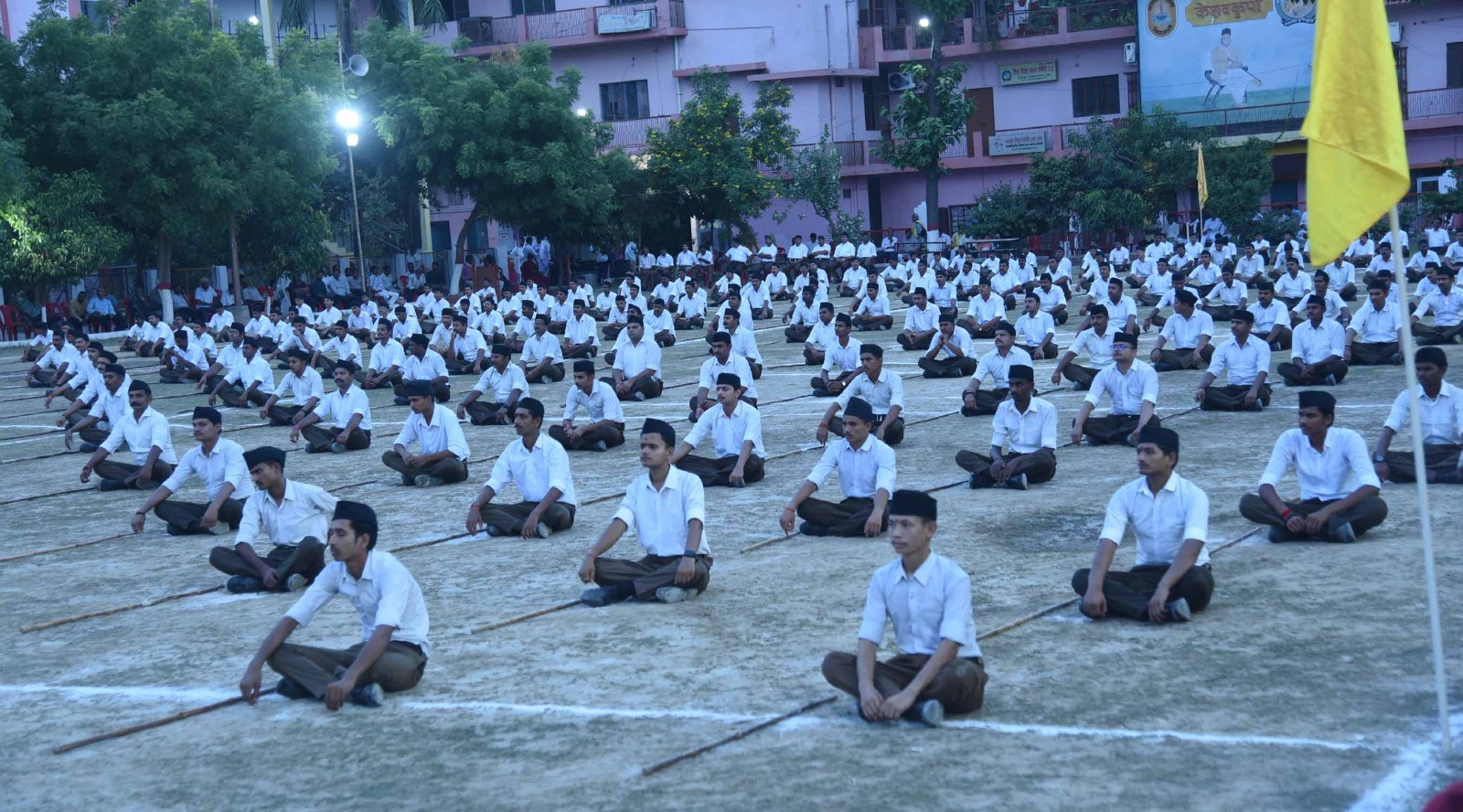 मैदान में बैठे स्वयंसेवक मैदान में बैठे स्वयंसेवक