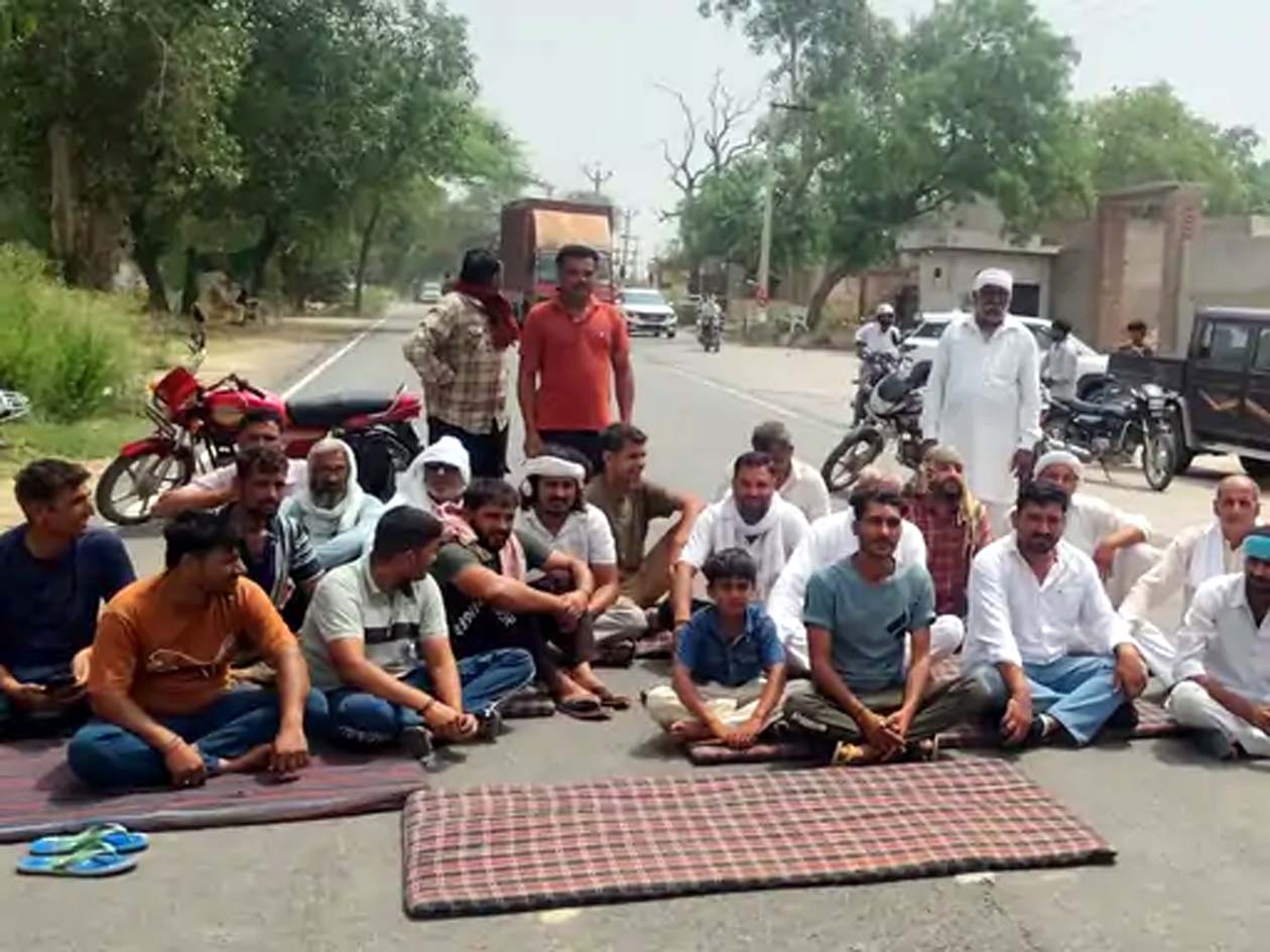 जाम के दौरान सड़क रोककर बैठे ग्रामीण। जाम के दौरान सड़क रोककर बैठे ग्रामीण।