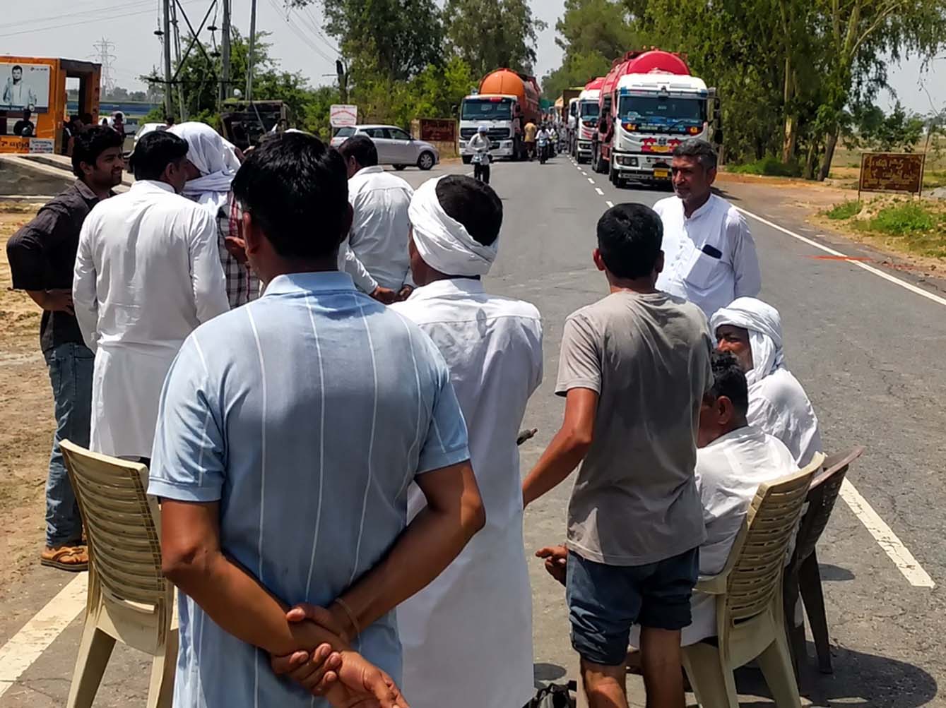 बरवाला रोड पर कुर्सी डालकर जाम लगाते किसान।