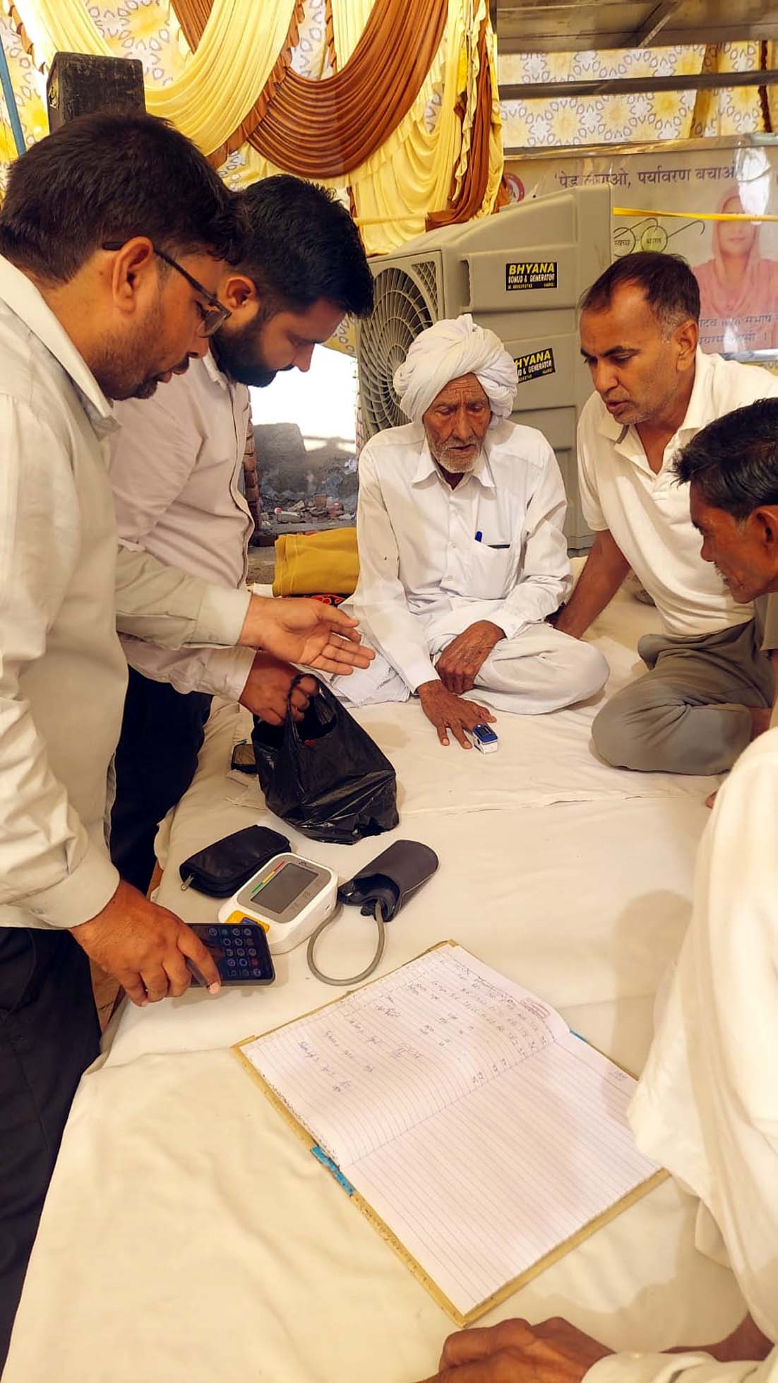 आमरण अनशन पर बैठे टेकराम की स्वास्थ्य जांच करते चिकित्सक।