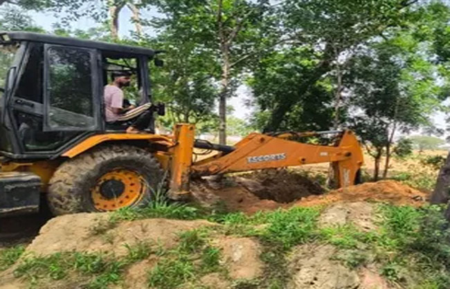 जेसीबी की मदद से गड्ढे में दबाते हुए मोर्टार।