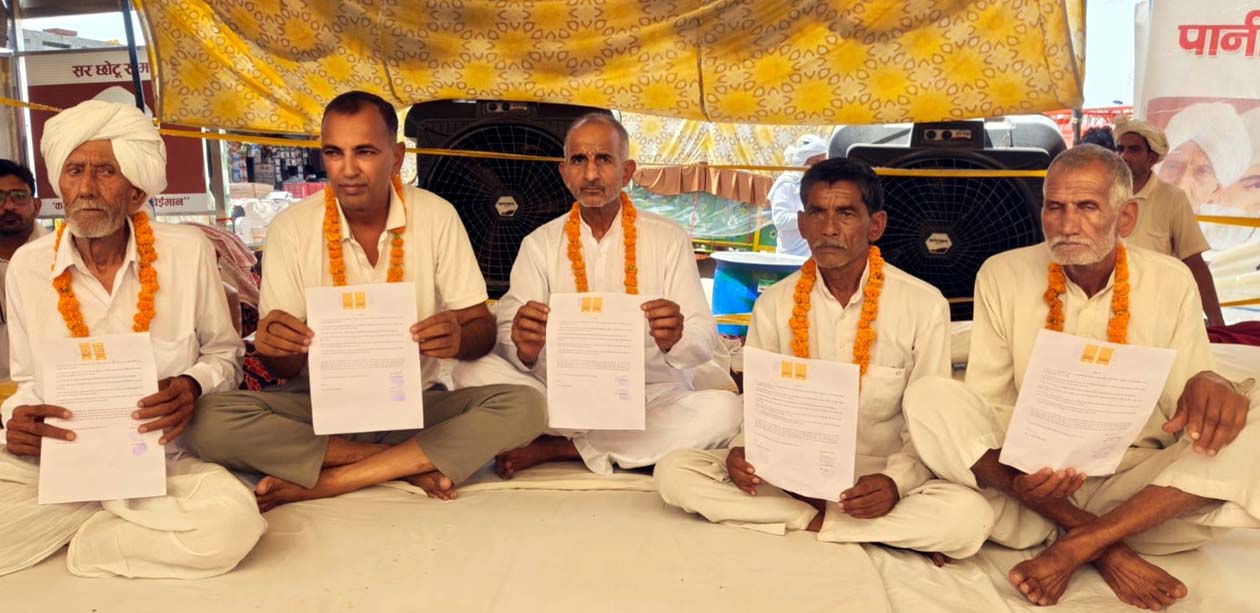 अपना शपथपत्र दिखाते आमरण अनशन पर बैठे अनशनकारी।