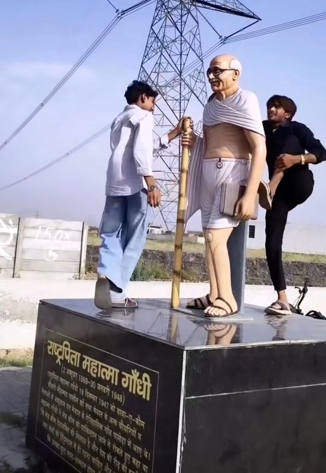 सोशल मीडिया पर वायरल हो रही एक वीडियो और तस्वीर में दो युवक गांधी पार्क में स्थापित महात्मा गांधी की प्रतिमा के कंधों पर बैठकर रील बनाते और मुस्कुराते हुए नजर आ रहे हैं।