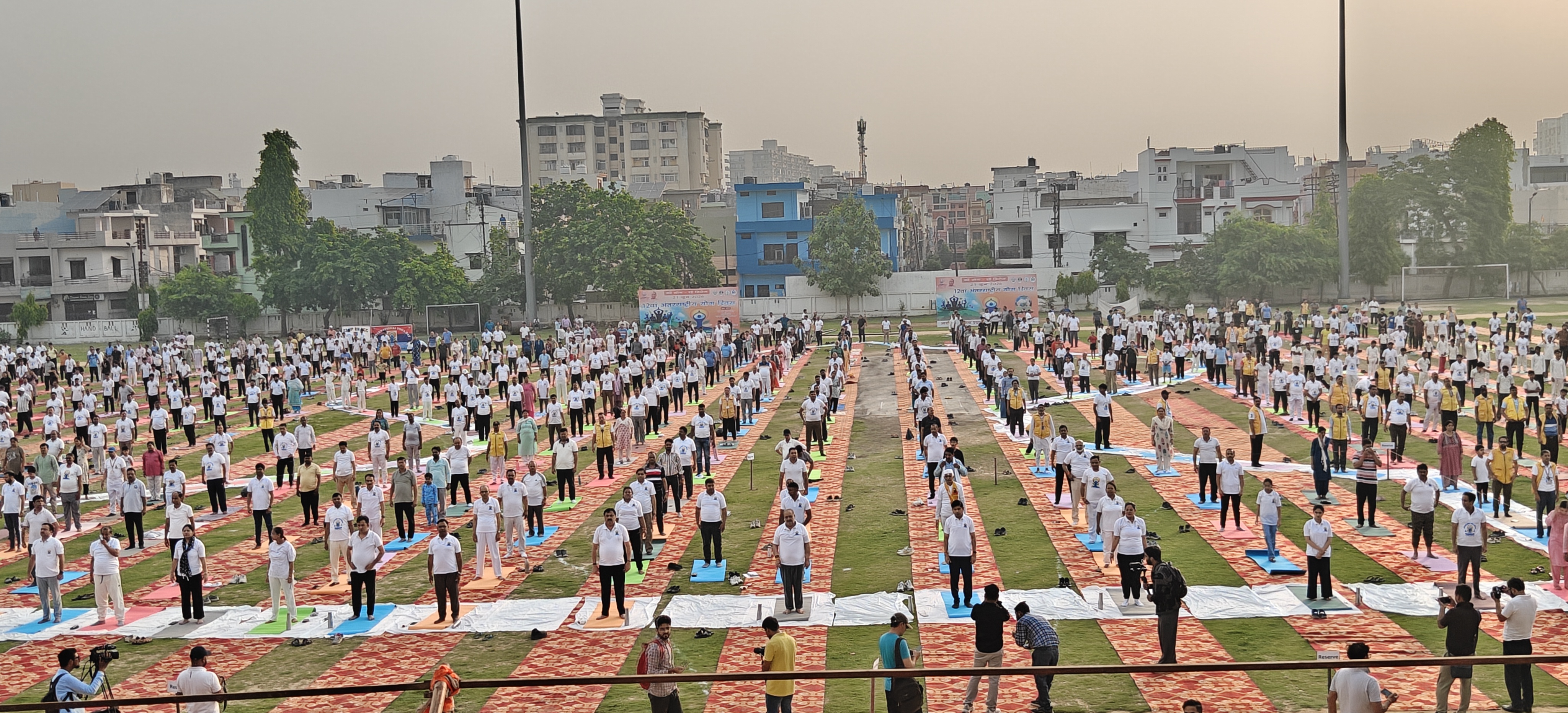 नेताजी सुभाष चंद्र बोस सोनकपुर स्पोर्ट्स स्टेडियम में सामूहिक योग दिवस कार्यक्रम में योग करते लोग।