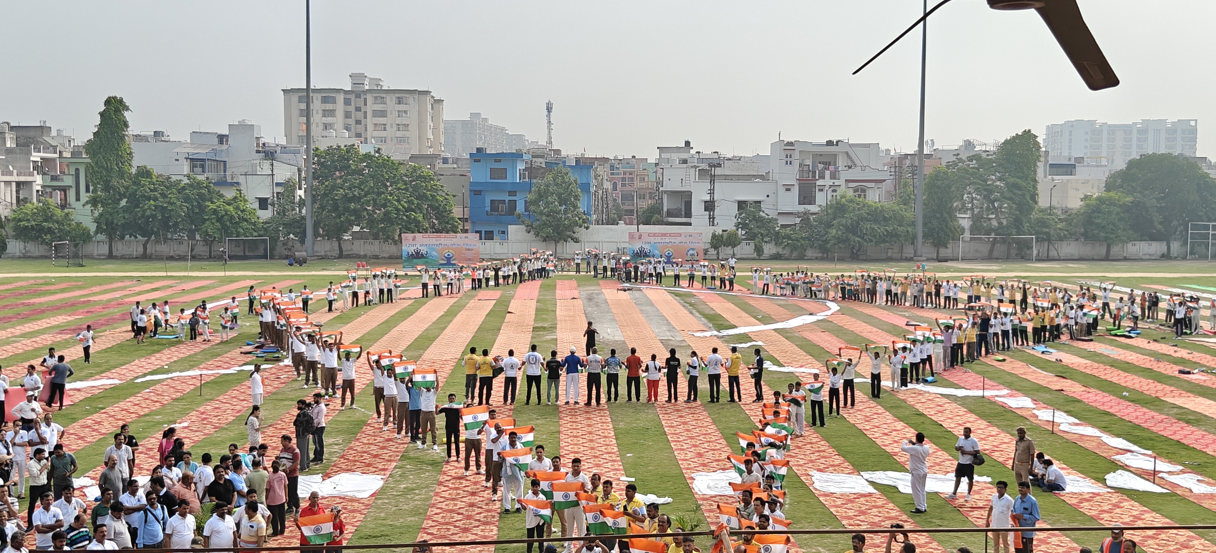 नेताजी सुभाष चंद्र बोस सोनकपुर स्पोर्ट्स स्टेडियम में सामूहिक योग दिवस कार्यक्रम में योग के बाद भारत के नक्शे की आकृति में खड़े लोग।