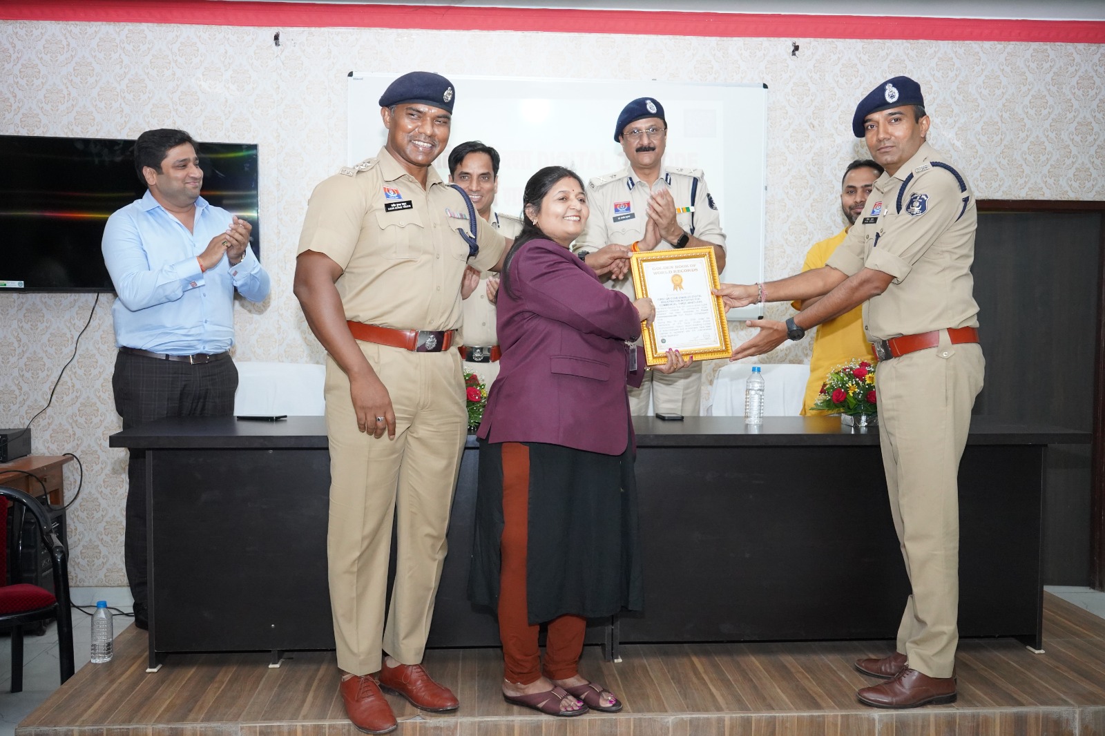 गोल्डन बुक ऑफ वर्ल्ड रिकॉर्ड्स की टीम पुलिस अधिकारियों को प्रमाण पत्र एवं मेडल प्रदान कर सम्मानित करते हुए