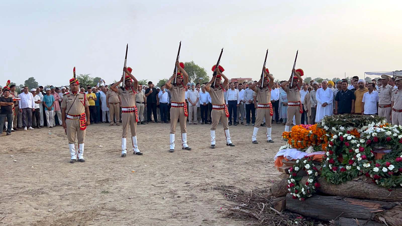 अंतिम संस्कार के अवसर पर सलामी देते पुलिस जवान।