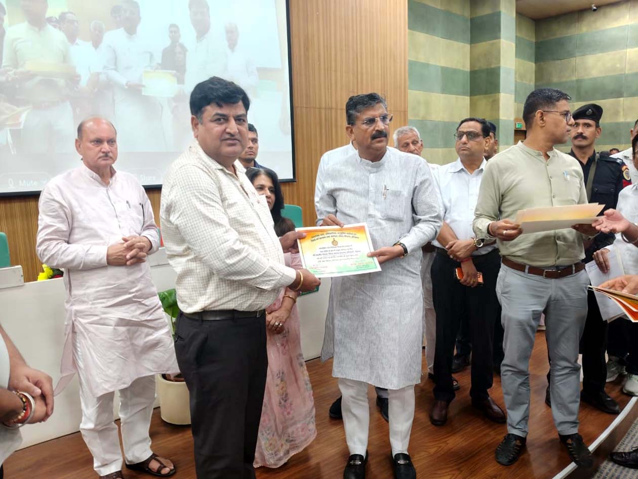 कैबिनेट मंत्री कृष्ण बेदी से राज्य पुरस्कार प्राप्त करते जिला समाज कल्याण अधिकारी महावीर गोदारा।