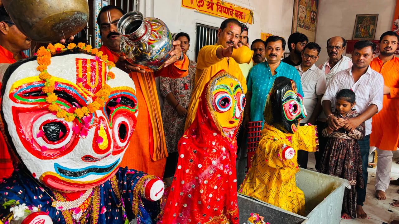भगवान जगरनाथ जी बलराम जी और बहन सुभद्रा को स्नान करवाते हुए श्रद्धालु लोग