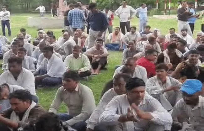 धरने पर बैठे हुए कर्मचारी।