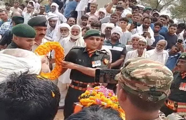 पुष्प चक्र अर्पित करते हुए सैनिक।