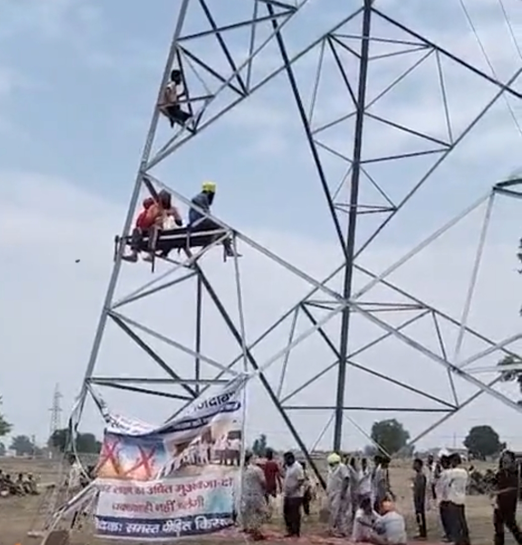 टावर पर चढ़े किसान।