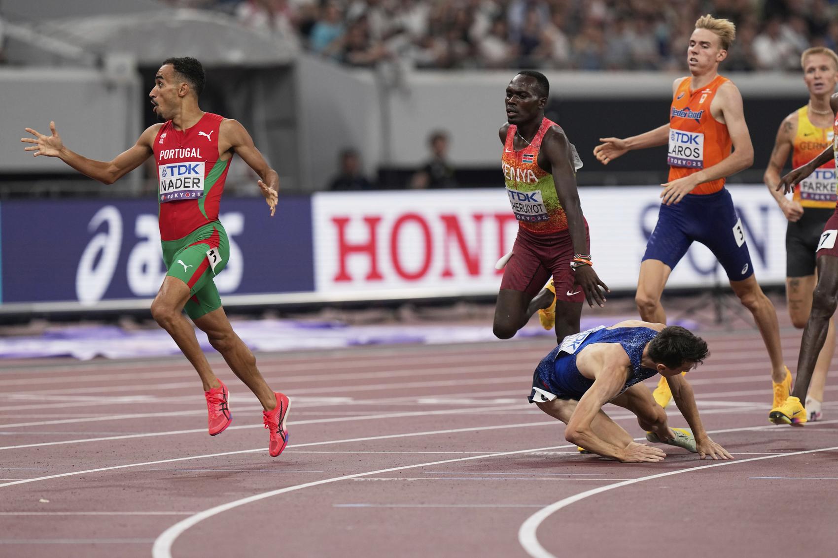Portugal's Isaac Nader, left, reacts after crossing the finish line to win the gold medal as Britain's Jake Wightman falls on the track in the men's 1,500 meters final at the World Athletics Championships in Tokyo on Wednesday.